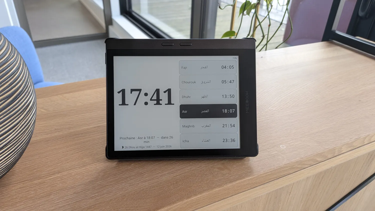 La tablette NUR posée sur un meuble, horaires de prière en paysage